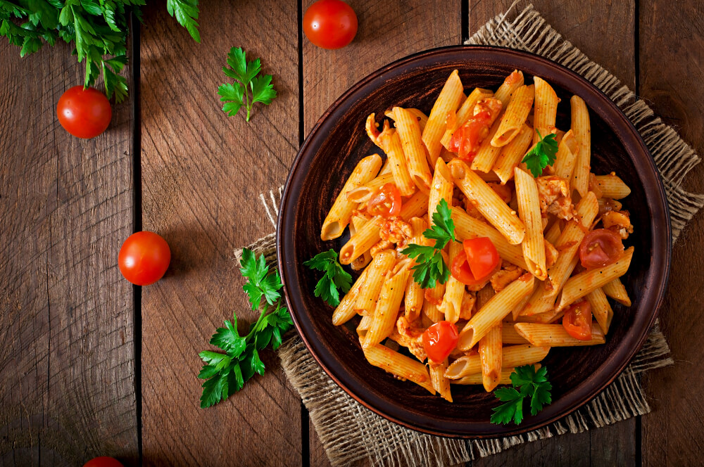 Pasta penne al sugo di pomodoro, con prezzemolo e pomodorini.
