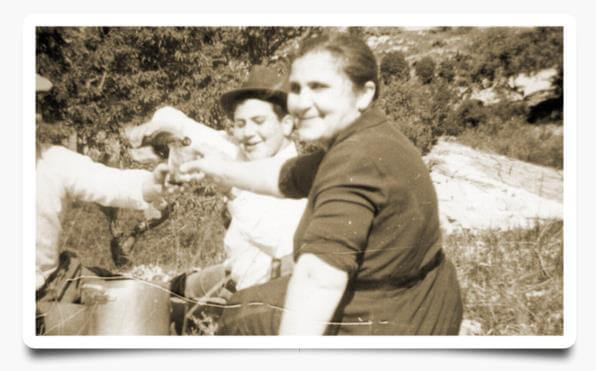 tre persone bevono vino, all'aperto.